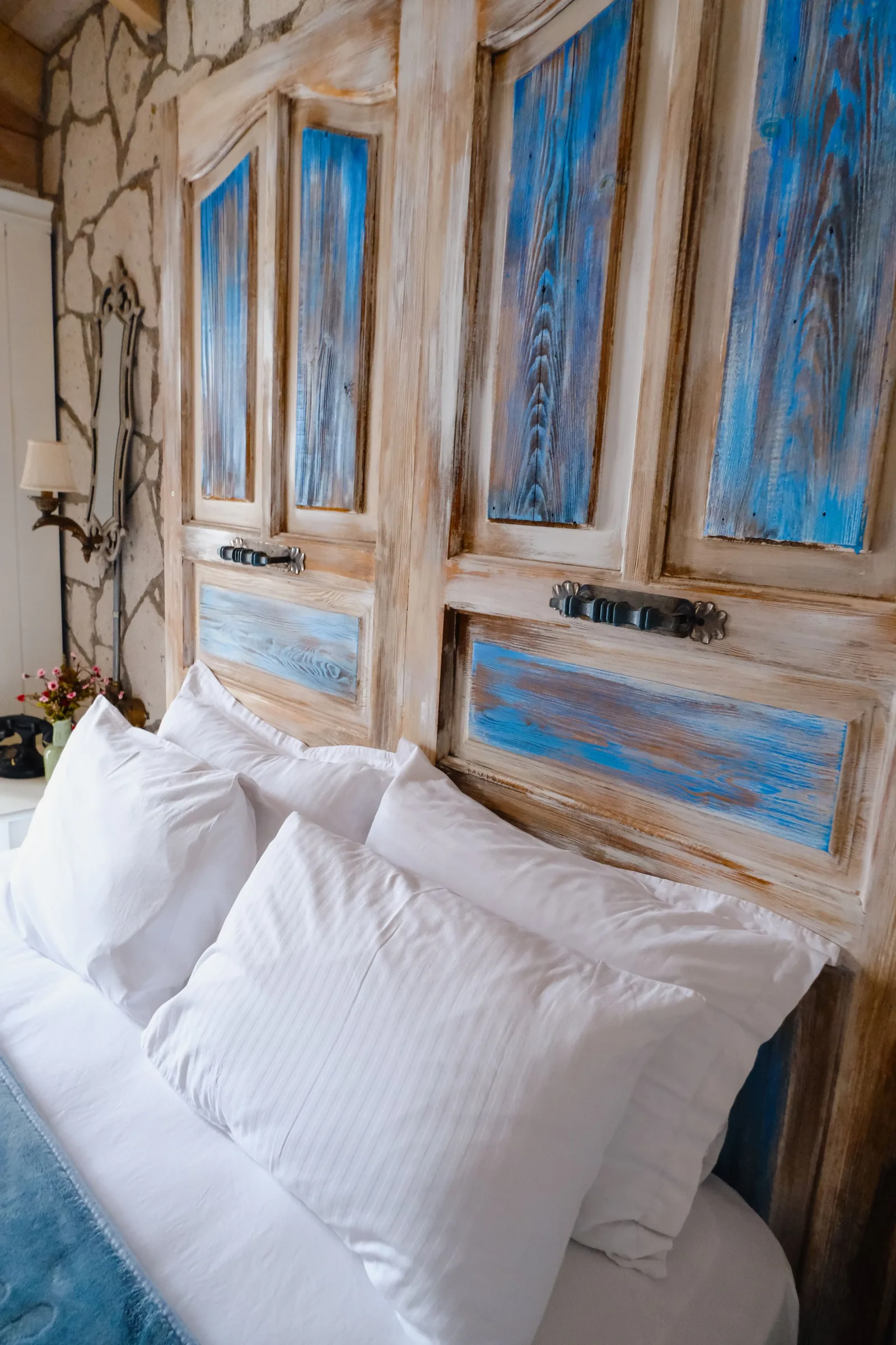 Old blue painted doors behind white pillows