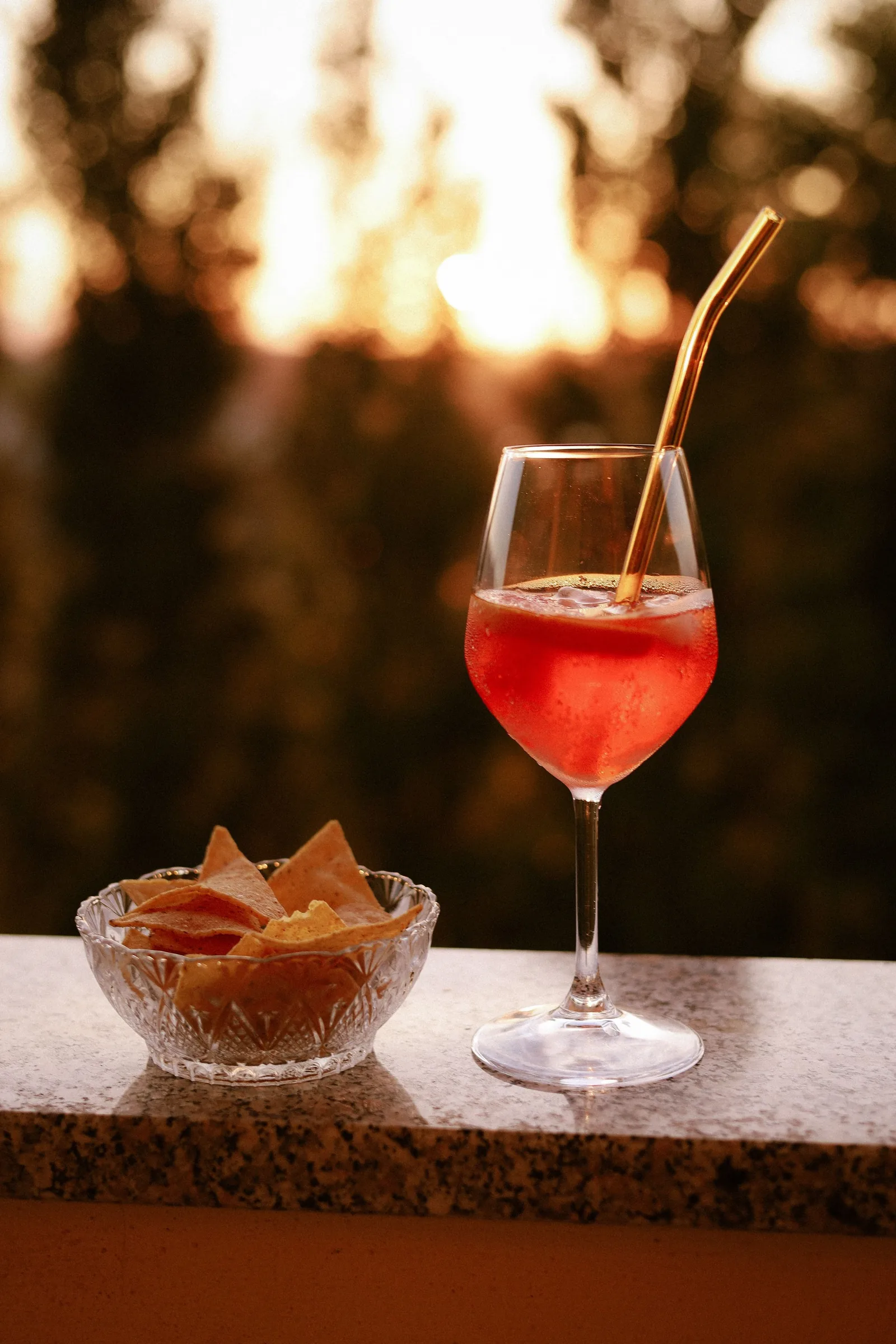 Red spritz with crisps on a small table